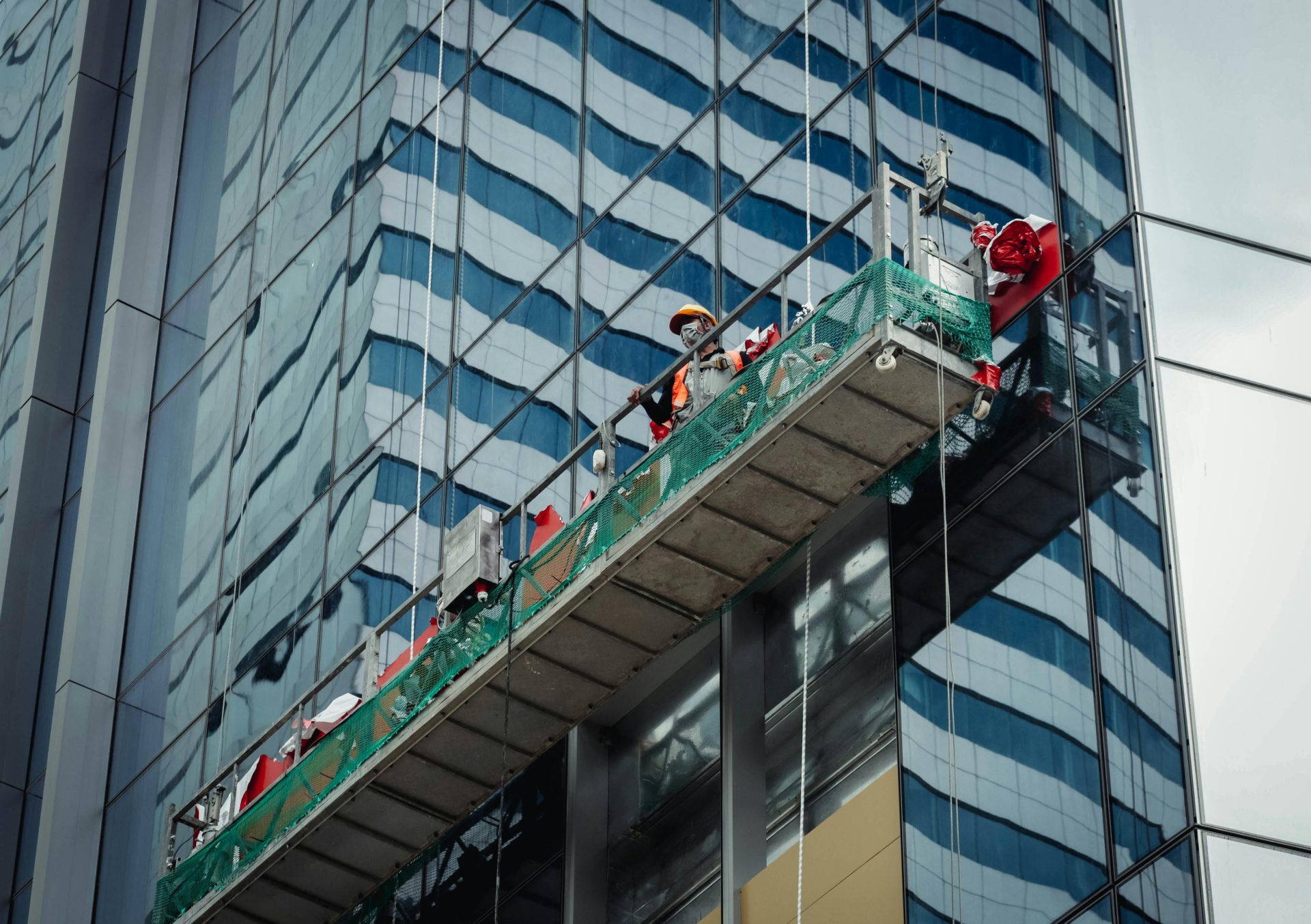 Ein städtischer Arbeiter putzt die Fenster eines Hochhauses in Ho-Chi-Minh-Stadt, Vietnam.