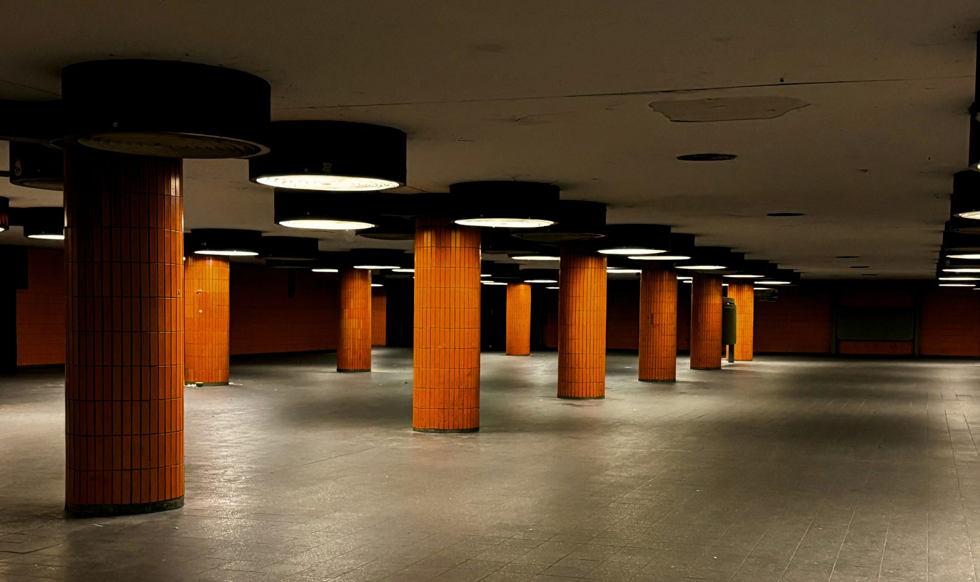 ein leeres Parkhaus mit orangefarbenen Säulen und Lichtern