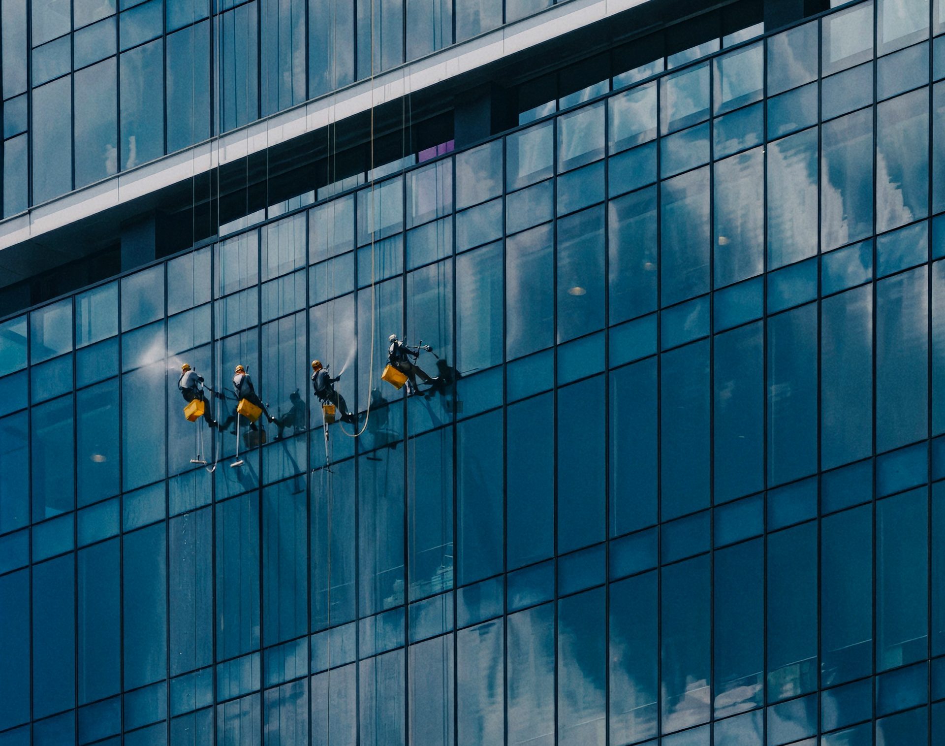 Fensterputzer arbeiten an einem modernen Glasgebäude